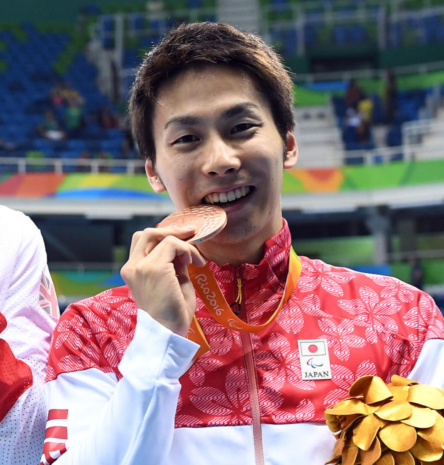 16年9月、リオデジャネイロ・パラリンピック競泳男子50メートル自由形（運動機能障害S9）表彰式で銅メダルをかんで笑顔の山田拓朗
