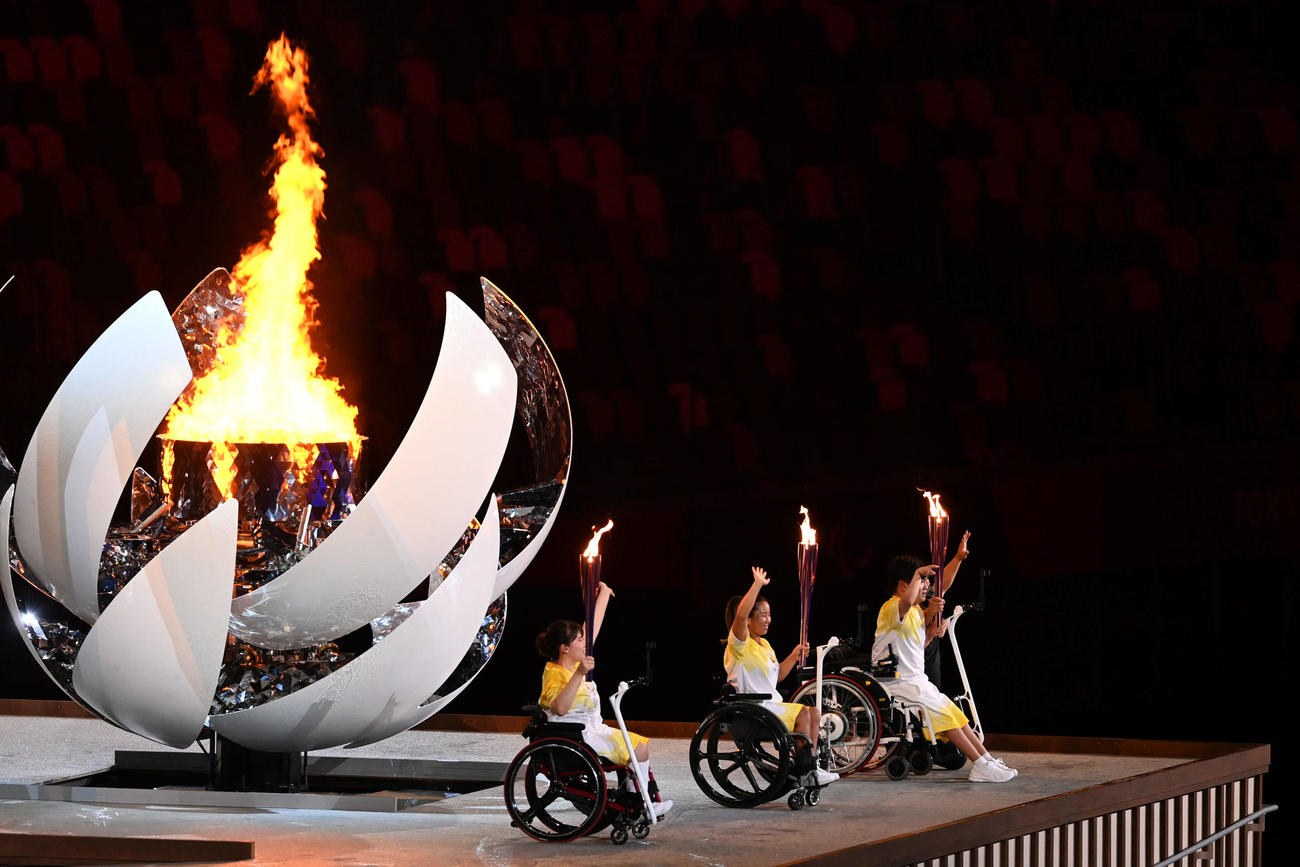 パラリンピックの開会式で聖火台に点灯し笑顔を見せる、左から森崎、上地、内田（撮影・山崎安昭）