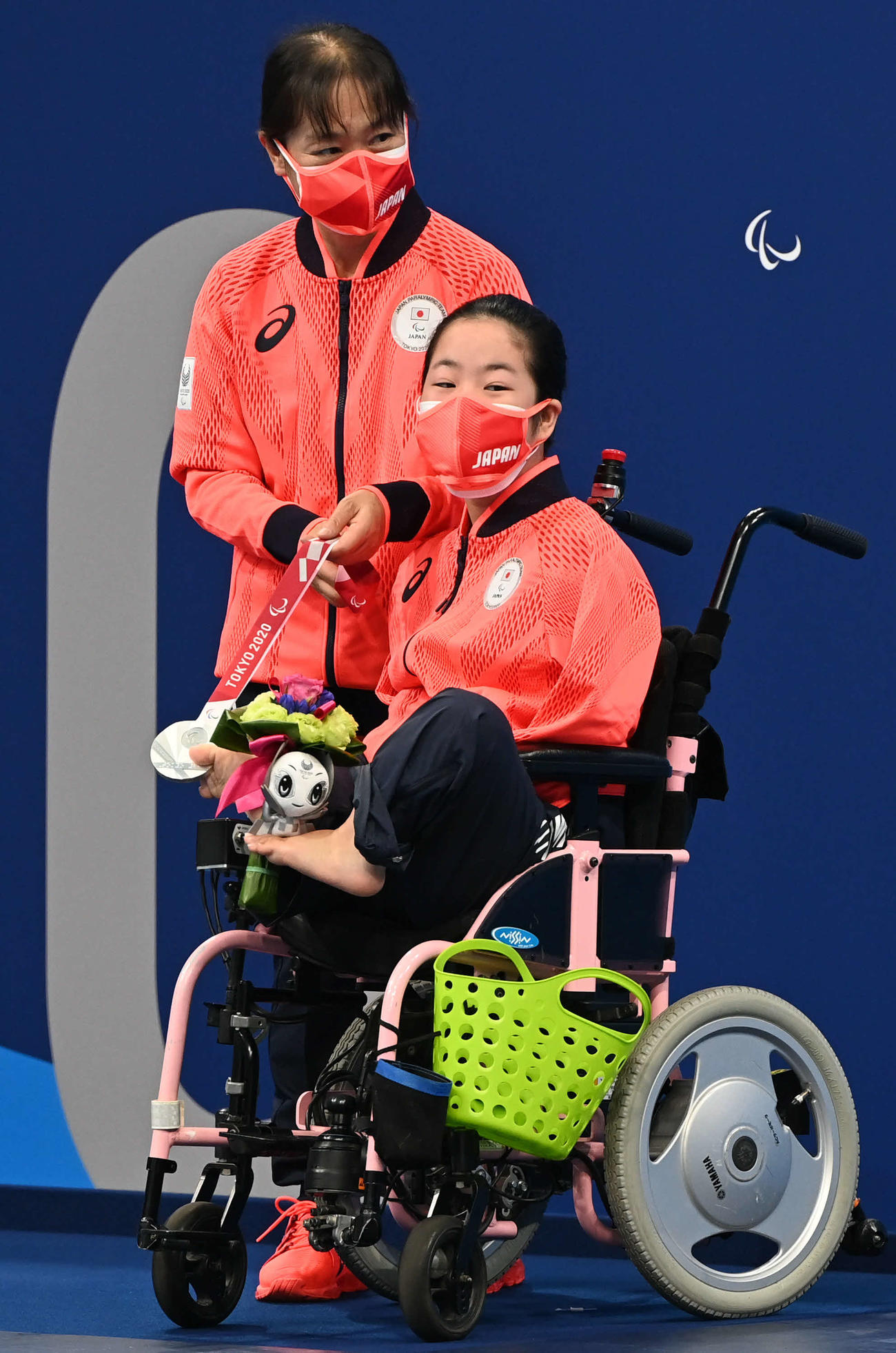 女子100メートル背泳ぎで銀メダルの山田（右）は足の指でメダルをはさむ（撮影・山崎安昭）