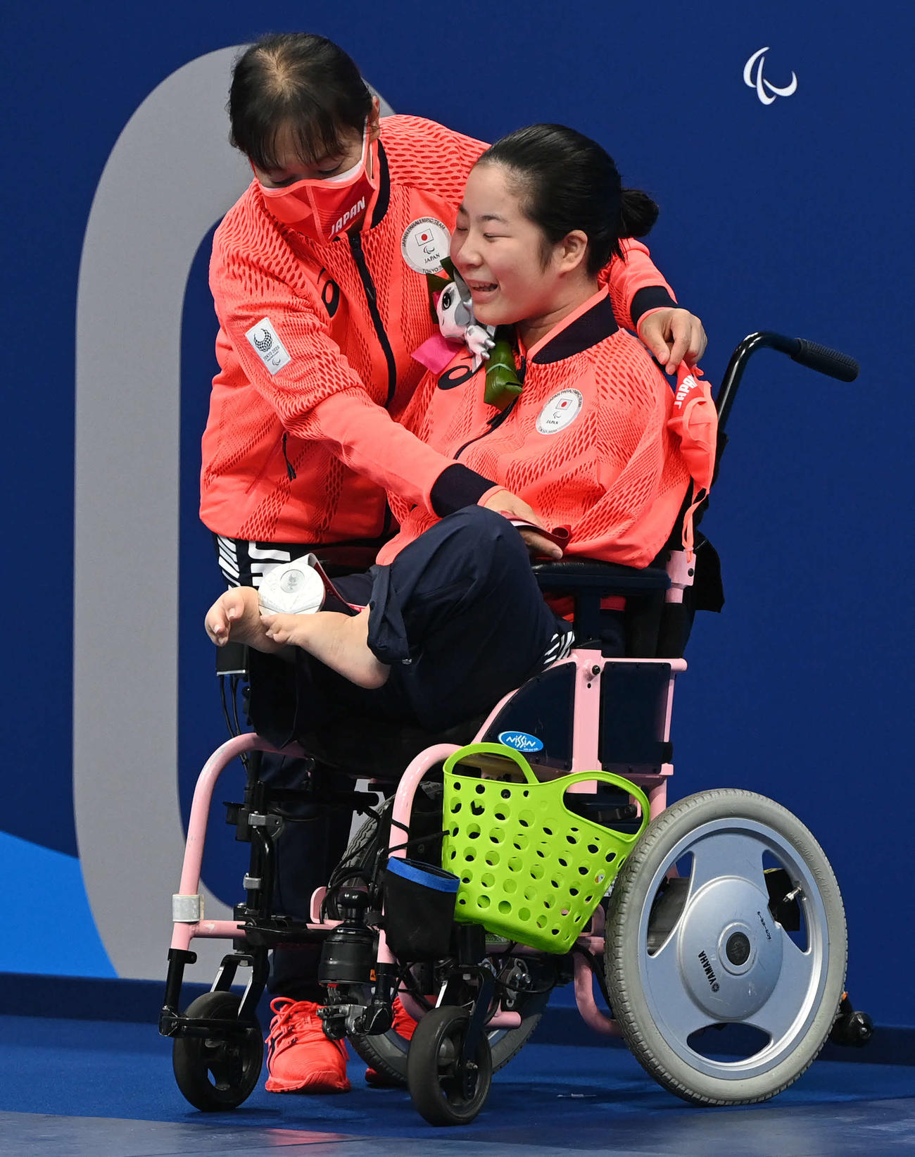 女子100メートル背泳ぎで銀メダルの山田（右）は両足でメダルをはさむ（撮影・山崎安昭）