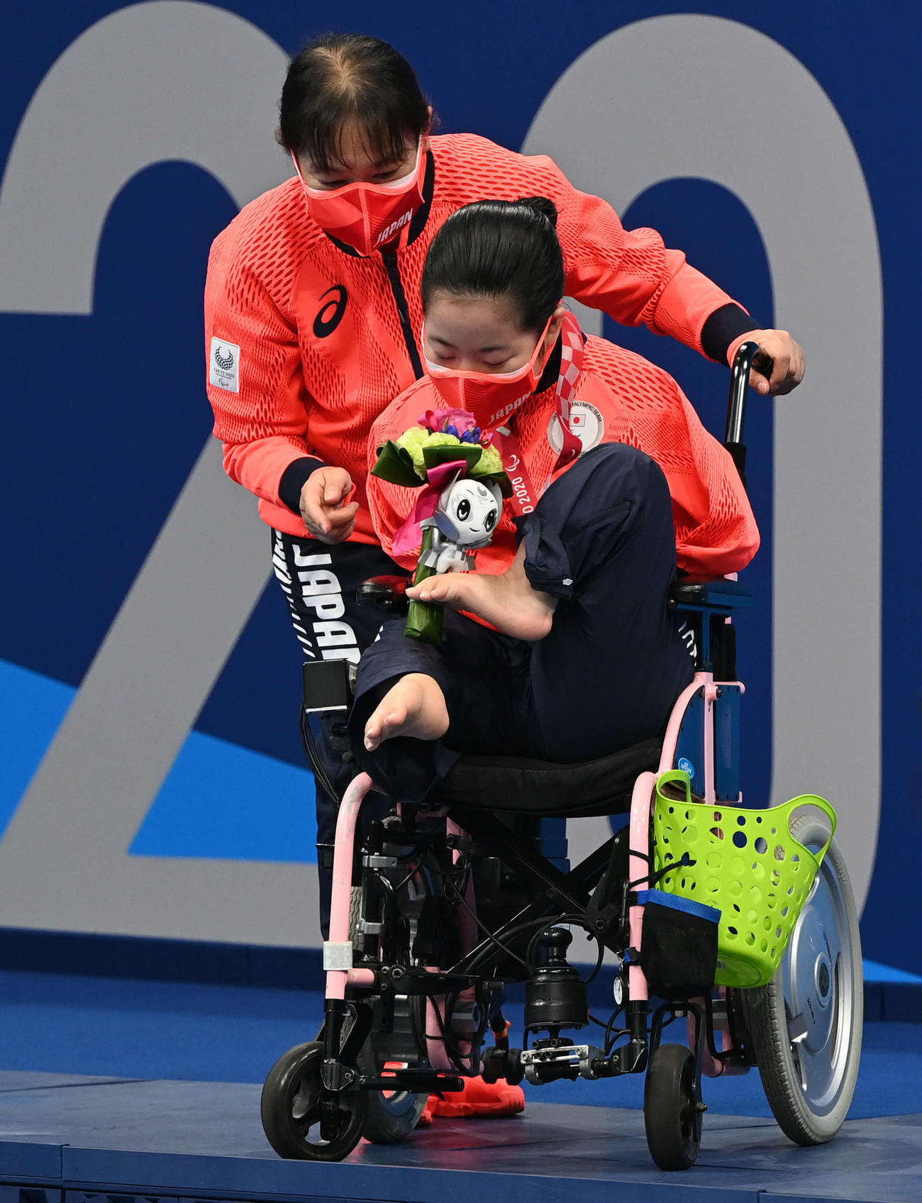 女子100メートル背泳ぎで銀メダルの山田（下）はブーケのにおいを嗅ぐ（撮影・山崎安昭）