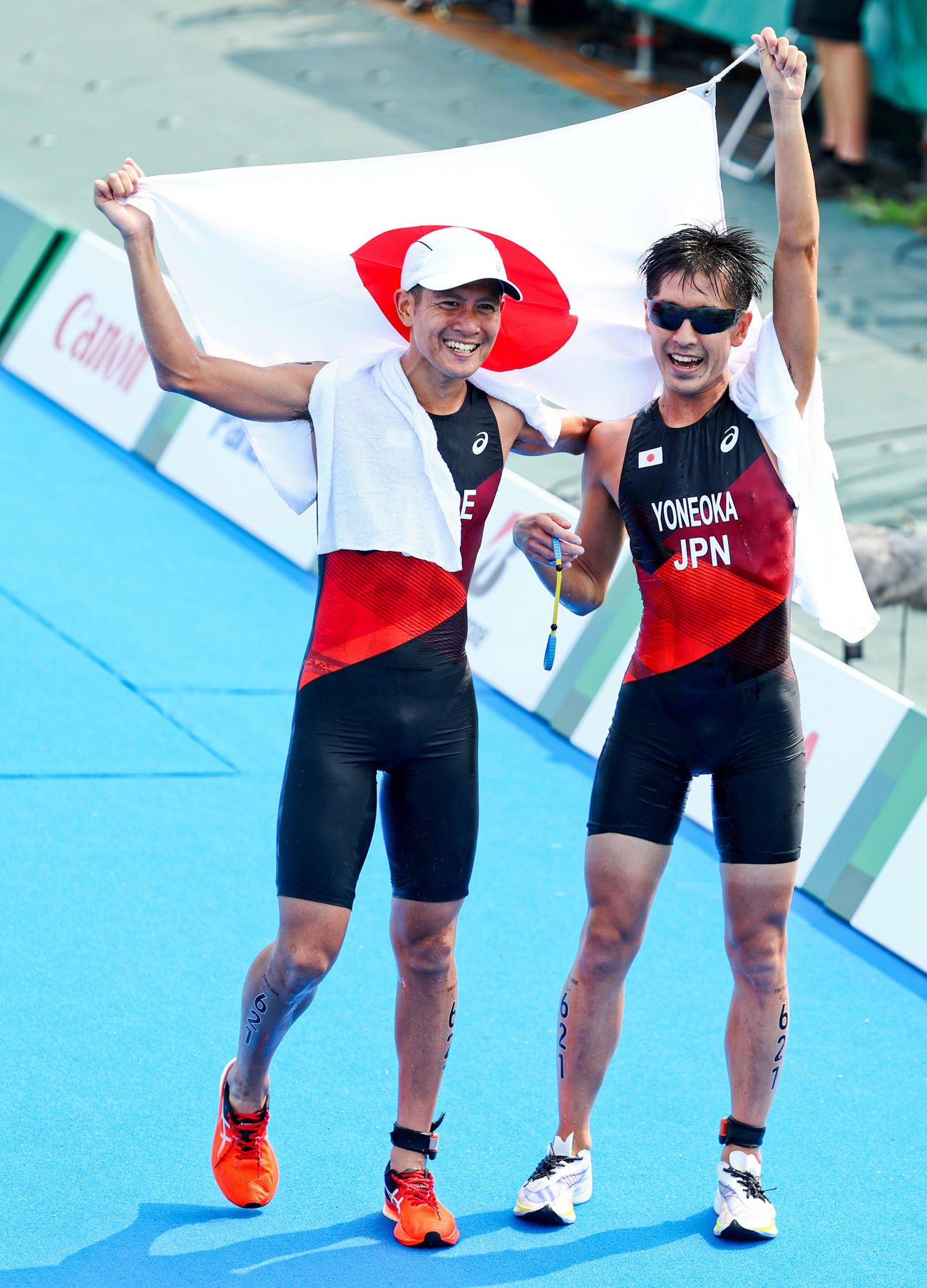 ガイドの椿（左）と3位でフィニッシュし、日の丸を掲げる米岡（撮影・河田真司）