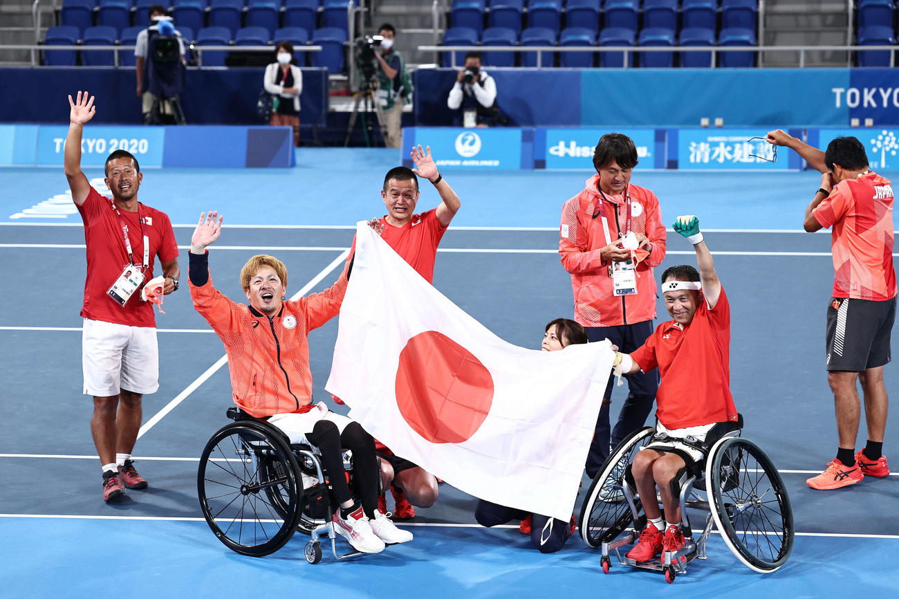 男子ダブルス3位決定戦　銅メダルを決め日の丸を掲げる菅野（左から2人目）と諸石（右から2人目）（撮影・河田真司）