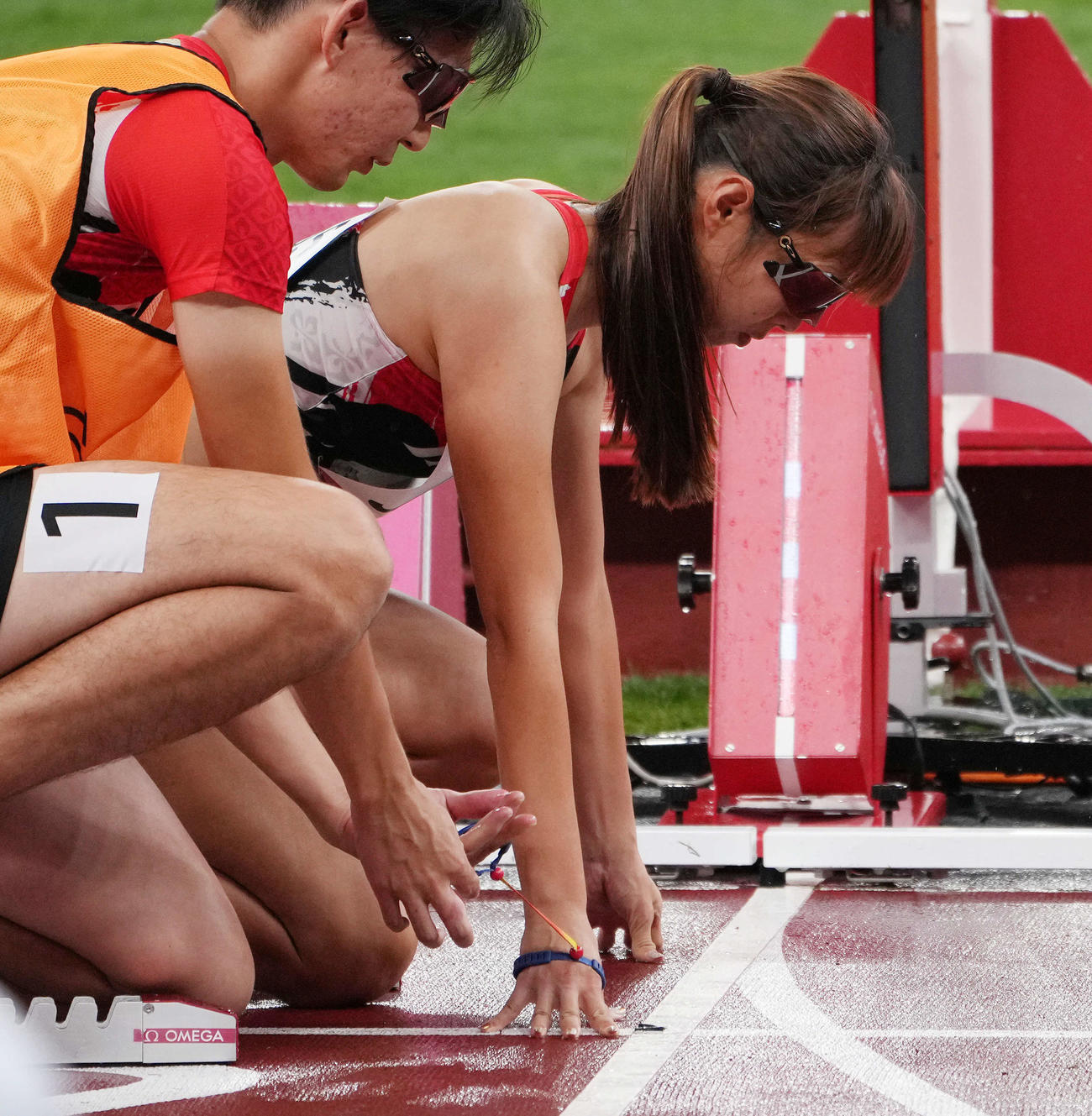 混合400メートルユニバーサルリレー決勝スタート前に、1走の沢田の手首のひもを手に取るガイドの塩川さん（撮影・滝沢徹郎）