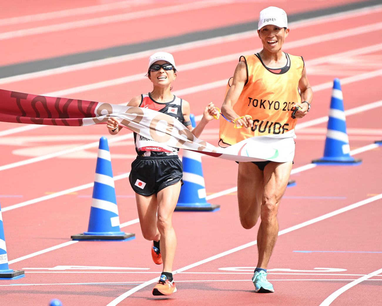 女子マラソン（視覚障害T12）金メダル獲得のゴールテープを切る道下（左）と伴走者（撮影・山崎安昭）