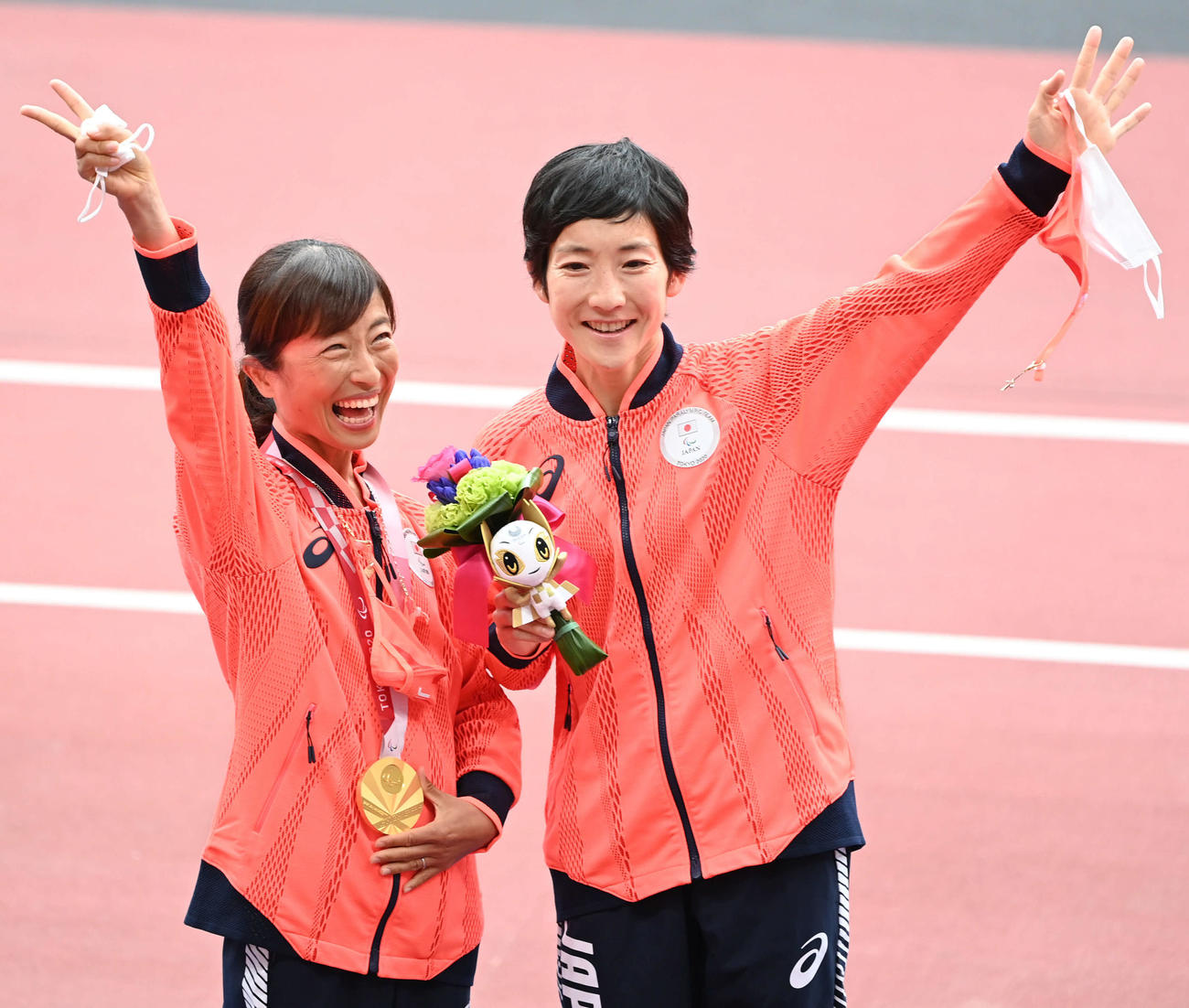 女子マラソン（視覚障害T12）　金メダルを手にした道下（左）は伴走者の青山由佳と一緒に笑顔を見せる（撮影・山崎安昭）