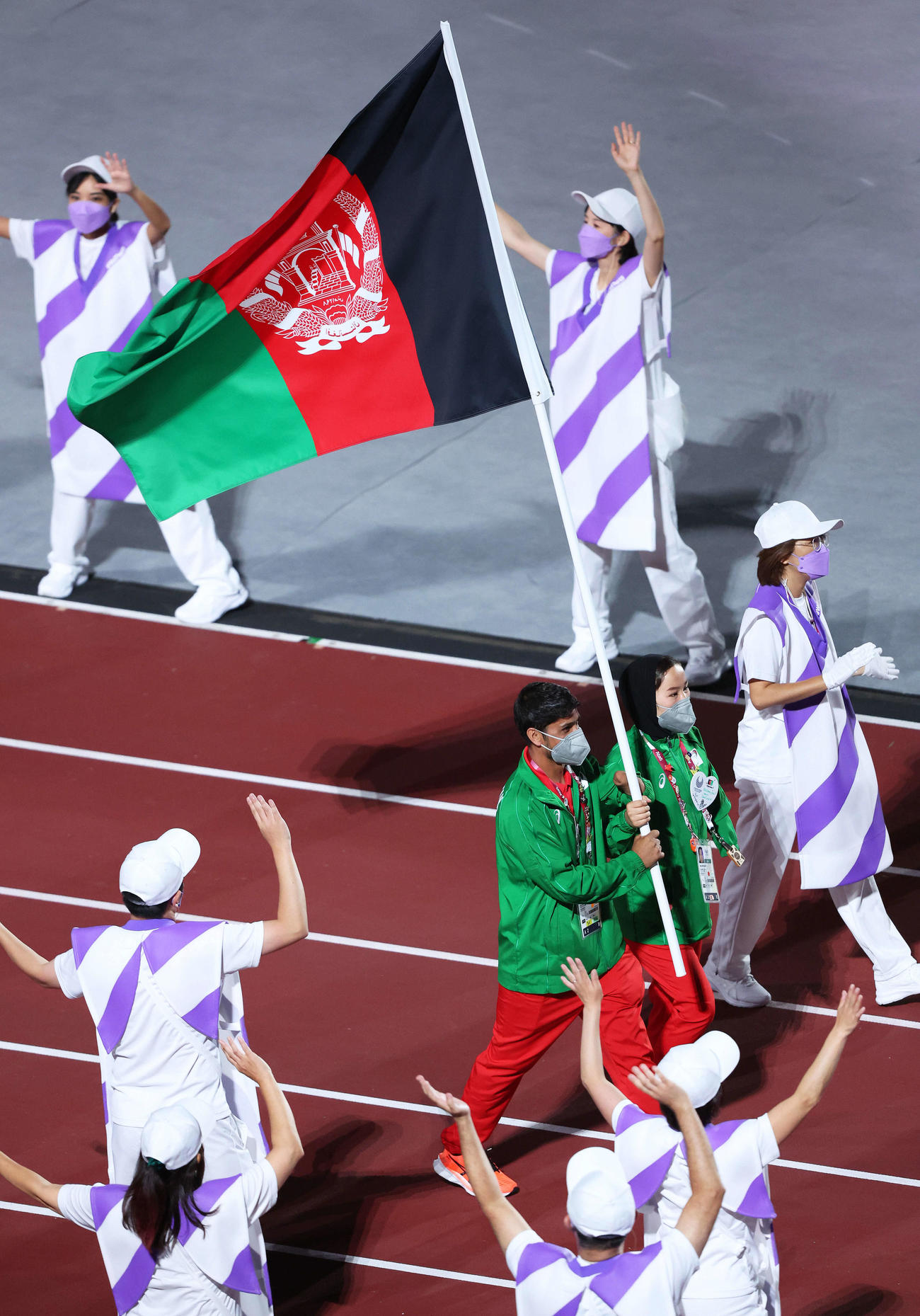 アフガニスタン国旗を手に競技場を歩くラスーリ（左）とフダダディ（撮影・河田真司）