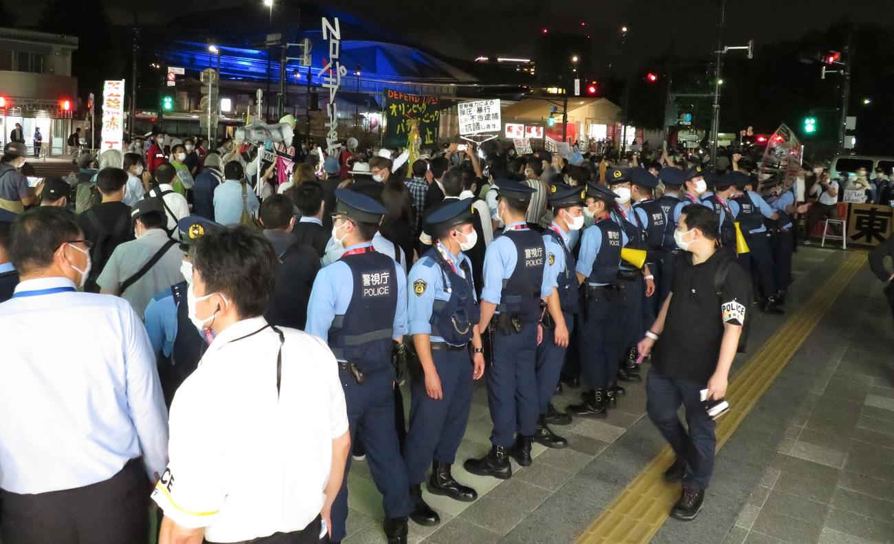 パラリンピック開催の反対活動を警察官が囲い込み、一般通行人の導線を確保した＝5日午後7時30分ごろ、JR千駄ヶ谷駅前