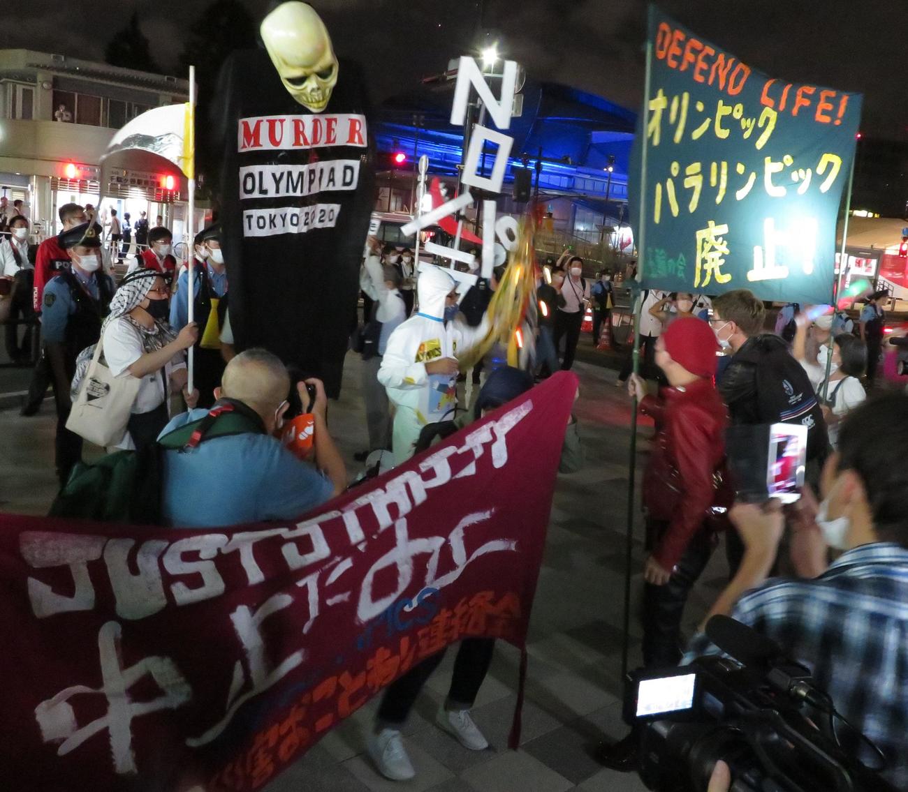 パラリンピックの閉会式会場に近いJR千駄ヶ谷駅前で、反対派はドクロのかぶりものや防護服などの仮装で「五輪はいらない」「パラもやめろ」などと叫んだ