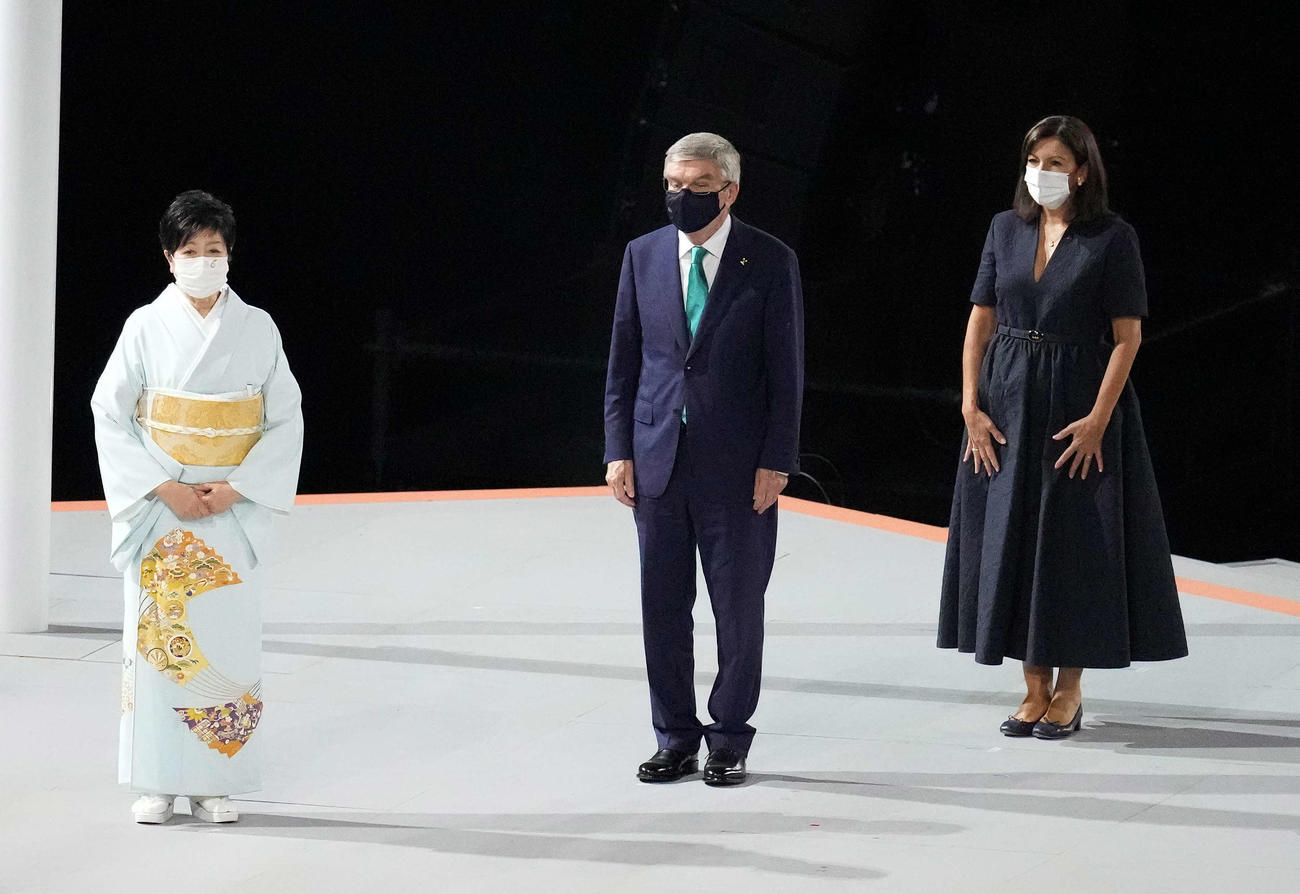 オリンピックの閉会式で登壇する小池都知事（左）とIOCバッハ会長（中央）（21年8月8日撮影）