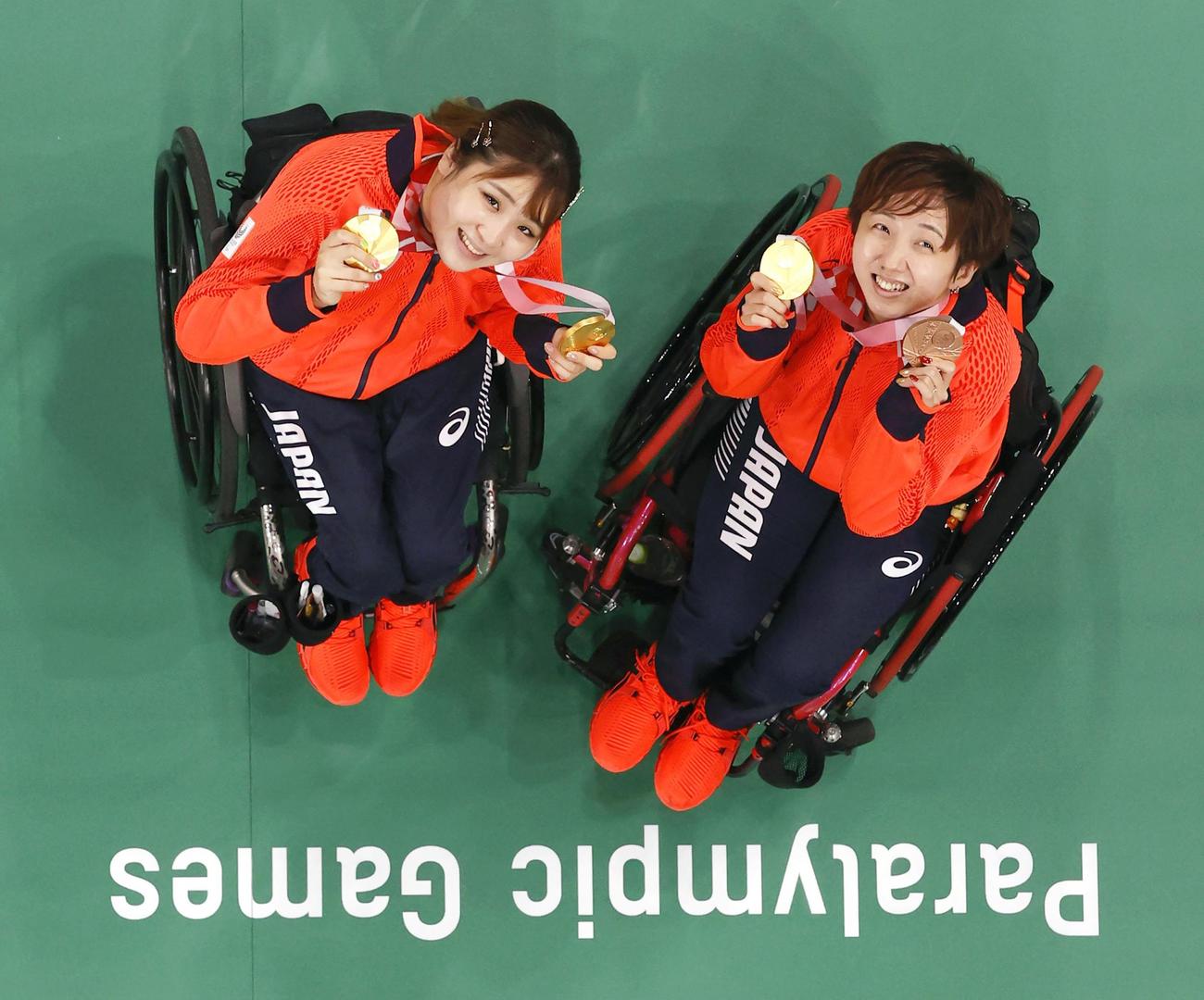 女子ダブルス（車いす）で優勝し、笑顔で金メダルを手にする里見紗李奈（左）、山崎悠麻組（共同）