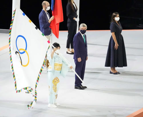 閉会式で五輪旗を振る小池都知事（左）。中央はIOCバッハ会長（撮影・鈴木みどり）