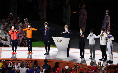 IOCバッハ会長（中央）のあいさつの際に阿部詩（左端）が壇上に上がり一緒にハートマークを作った。中央右は東京五輪・パラリンピック組織委員会の橋本聖子会長（撮影・河野匠）