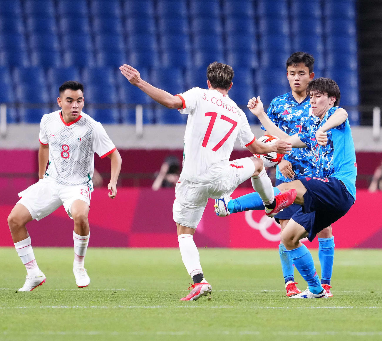 日本対メキシコ　後半、激しく競り合う田中（右）。後方右は久保（撮影・江口和貴）