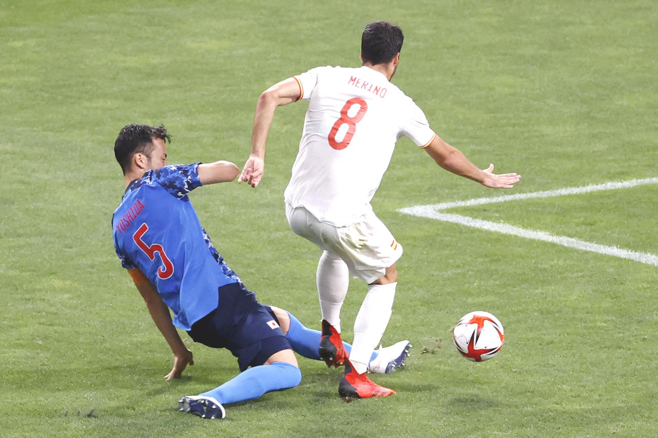 日本対スペイン　後半、スペインのメリノ（右）と交錯する吉田。PK判定はこの後、VARで取り消された（共同）