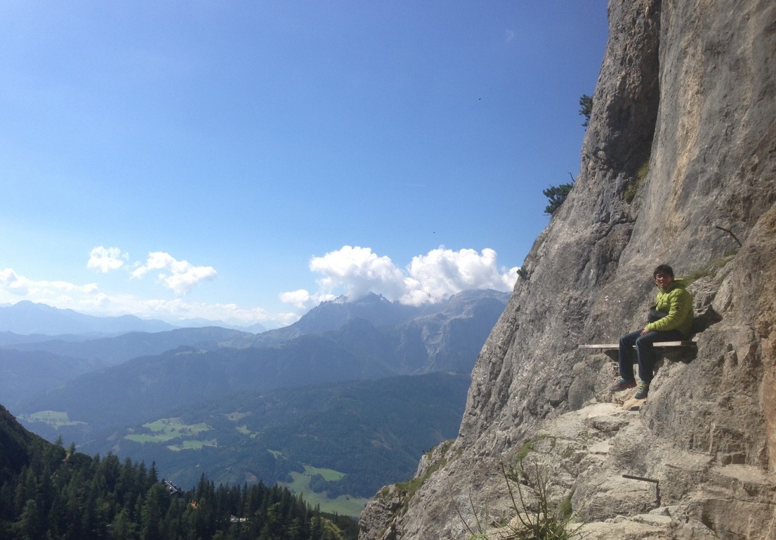 オーストリア・アイスリーゼンベルト入口の板に座り、アルプスの山々を眺める杉本怜（本人提供）