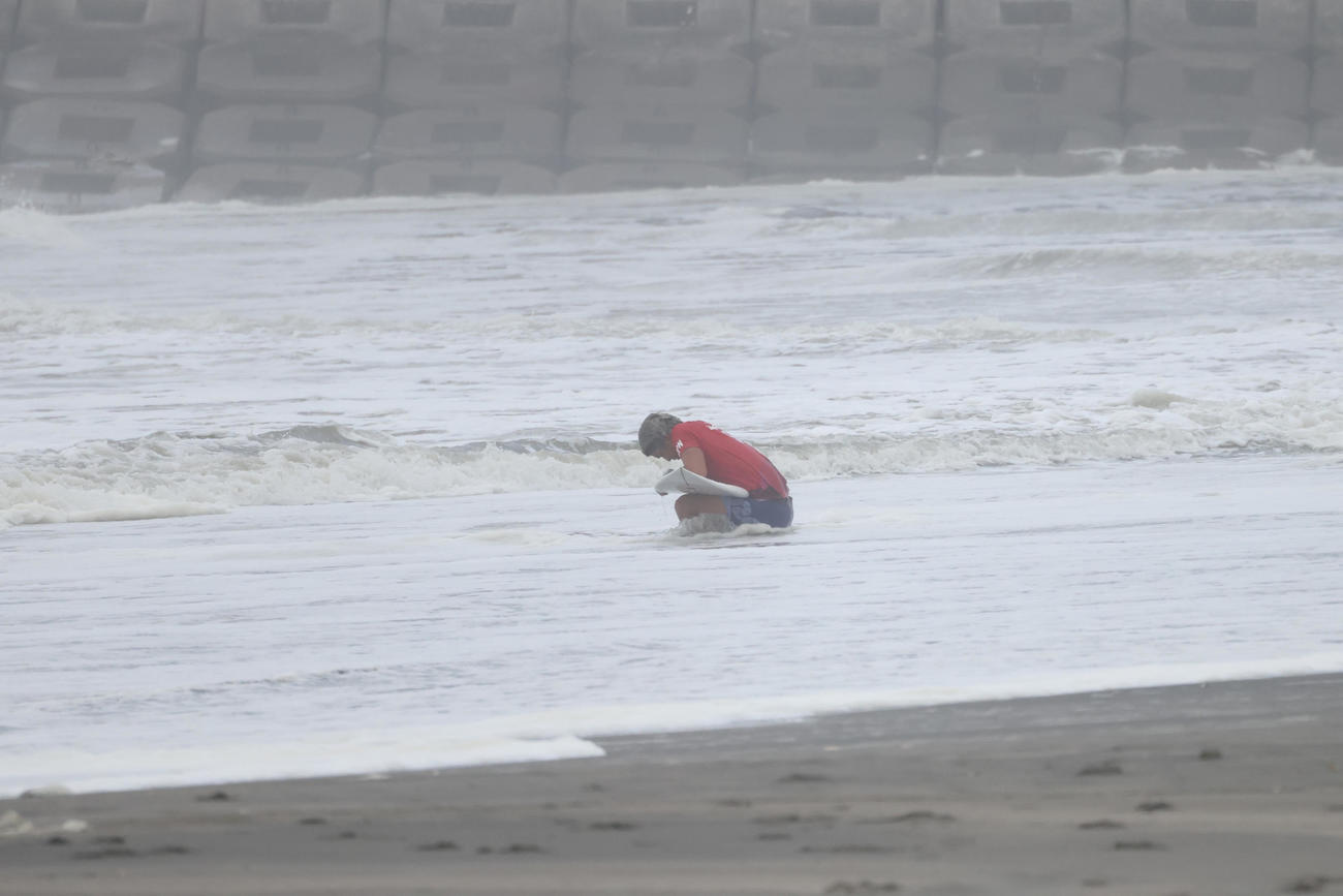 サーフィン男子決勝　銀メダルに終わり波打ち際でボードを抱えながらうなだれる五十嵐カノア（撮影・井上学）