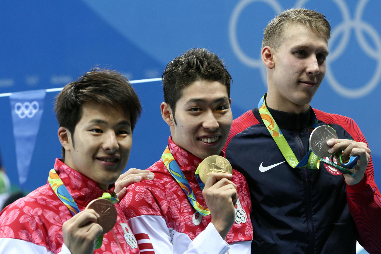 16年8月、リオデジャネイロ五輪表彰式で金メダルを手に笑顔を見せる萩野（中央）と3位の瀬戸（左）