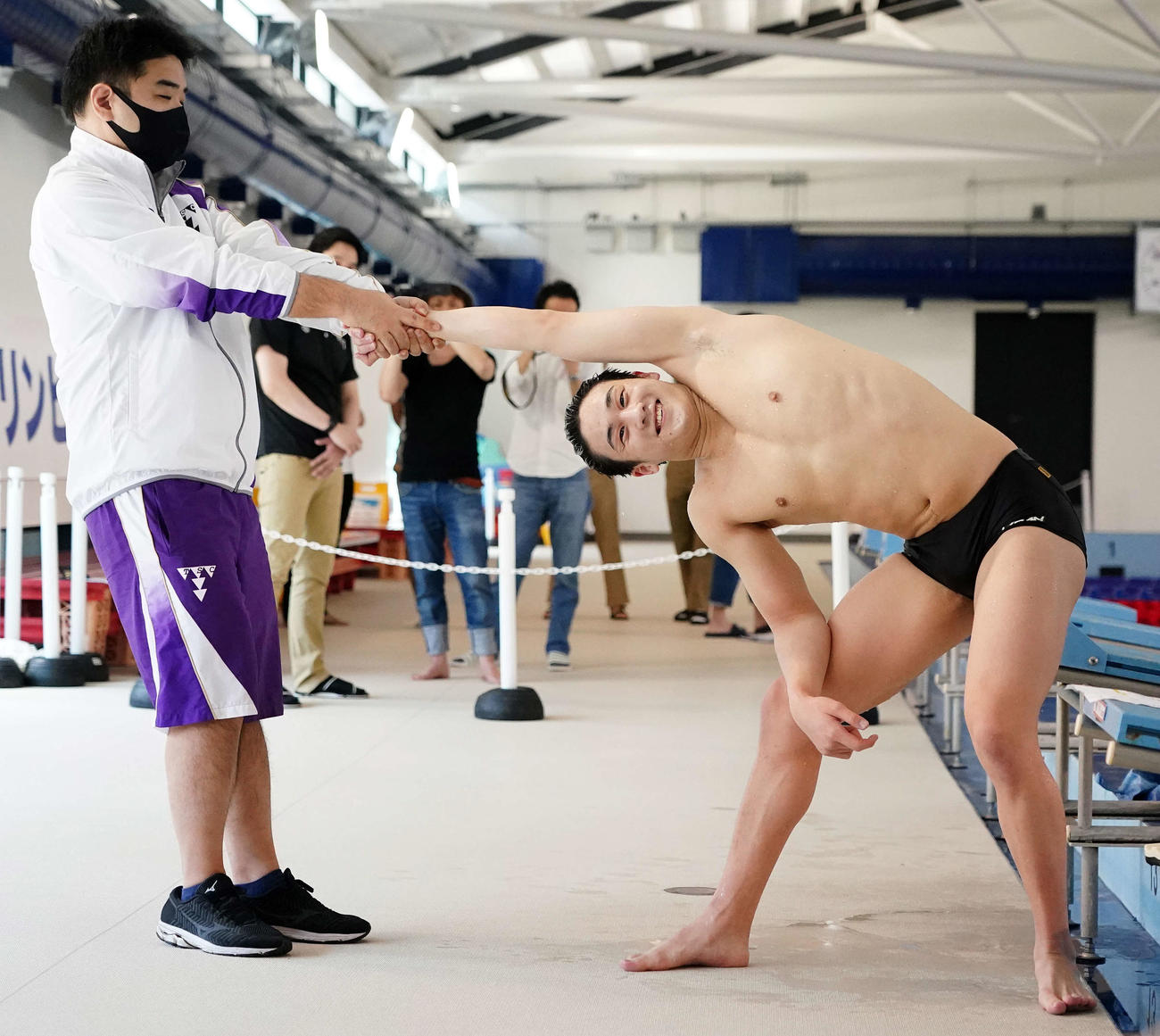 公開練習を終え、ストレッチする競泳五輪代表の佐藤（右）。左は西条コーチ（撮影・江口和貴）