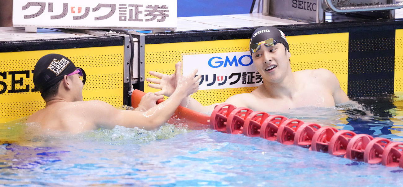 男子400メートル個人メドレーで優勝した瀬戸（右）は田渕と笑顔でタッチを交わす（撮影・鈴木みどり）