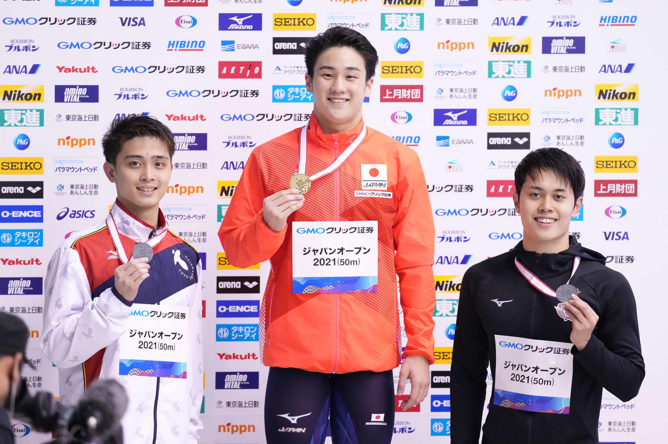 男子100メートル平泳ぎで優勝した佐藤（中央）は表彰台で笑顔。左は2位の花車、右は2位の平河（撮影・鈴木みどり）