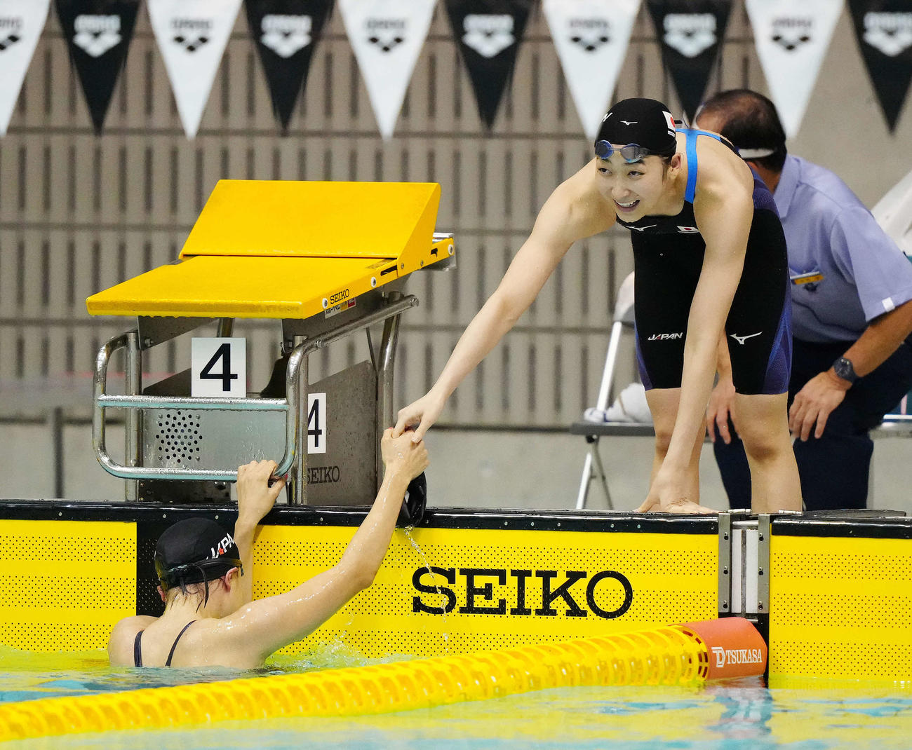 神奈川・相模原市水泳協会の「サマーチャレンジ記録会」で出場した女子200メートルリレーで日本新記録を樹立し大本（左）と握手をかわす池江（撮影・江口和貴）