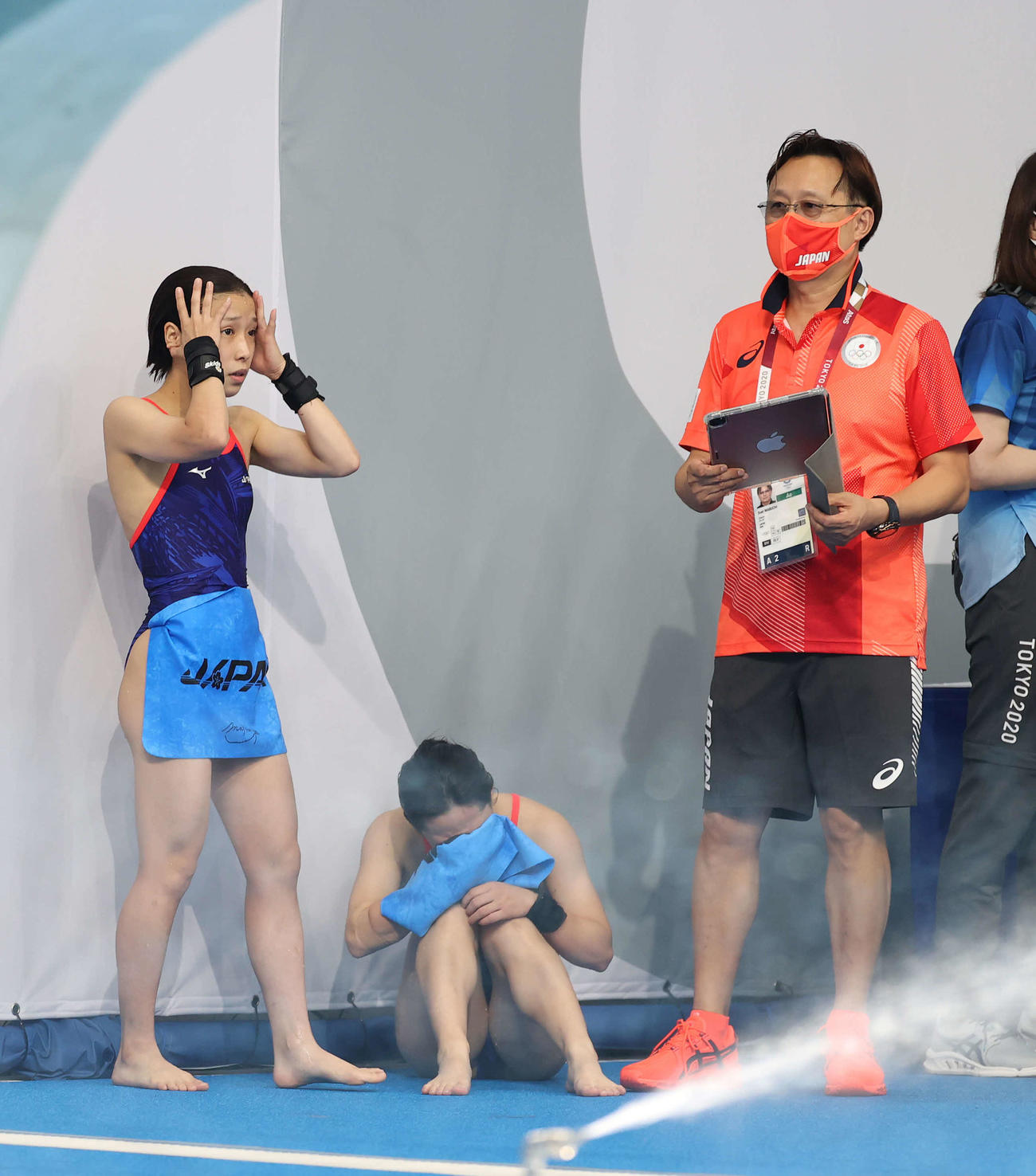 女子シンクロ高飛び込み決勝、5本目を終えぼうぜんとする荒井（左）と涙を見せる板橋（中央）。右は馬淵コーチ（撮影・河野匠）