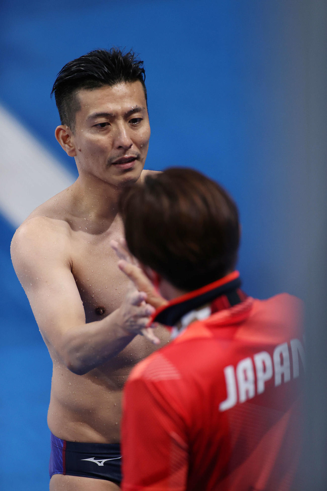 男子板飛び込み決勝、6本目の演技を終え、馬淵コーチ（手前）に迎えられる寺内（撮影・河野匠）