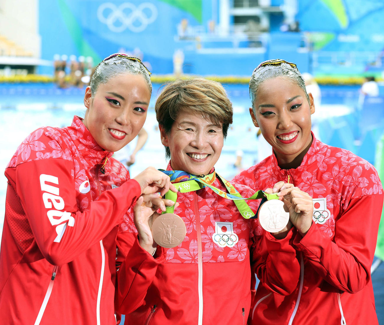 リオデジャネイロ五輪で銅メダルを獲得した乾友紀子（左）三井梨紗子（右）組は、この日が誕生日の井村雅代ヘッドコーチに誕生日プレゼントとなるメダルをプレゼントし、笑顔で写真撮影する（2016年8月16日）