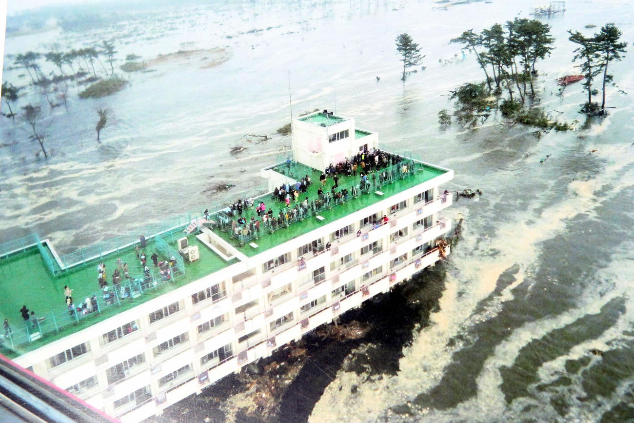 震災遺構となった荒浜小の震災当時の様子。津波が押し寄せ、屋上に多くの人が避難している