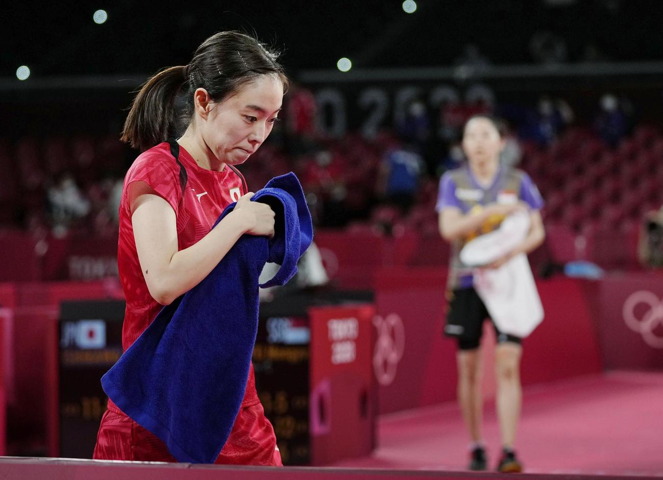 女子シングルス準々決勝でシンガポール選手（奥）に敗れ、肩を落とす石川佳純（共同）