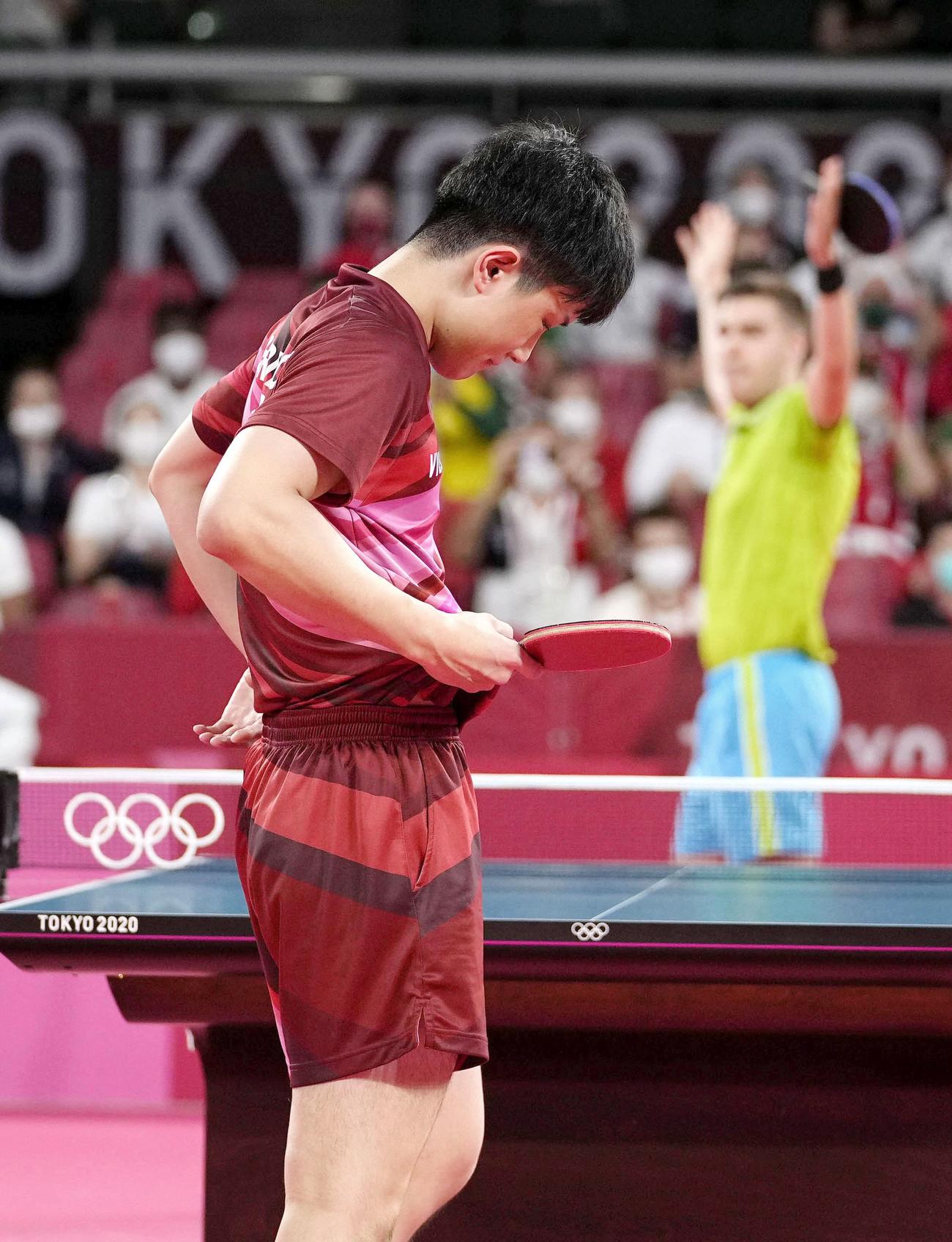 男子シングルス4回戦でスロベニア選手（奥）に敗れ、うなだれる張本智和＝東京体育館（共同）