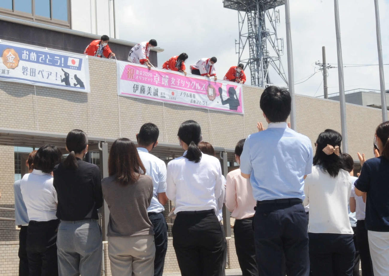 職員ら（手前）の拍手の中、庁舎南側に祝福の横断幕が追加された
