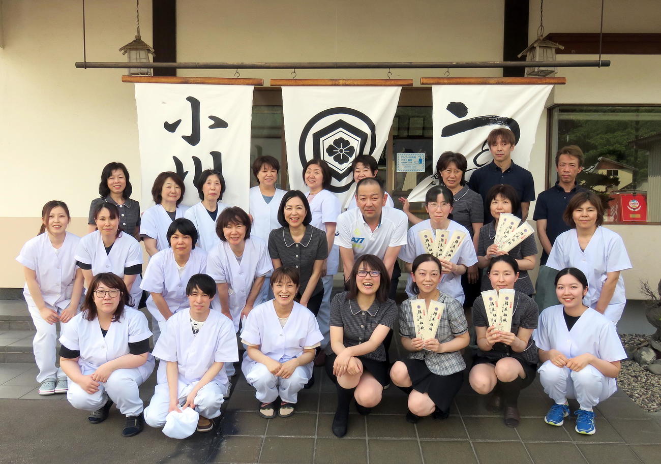 「稲庭うどん小川」店舗前で社員らの激励を受ける小川選子さん（中列左から5人目）。右隣は夫の小川博和社長（撮影・鎌田直秀）
