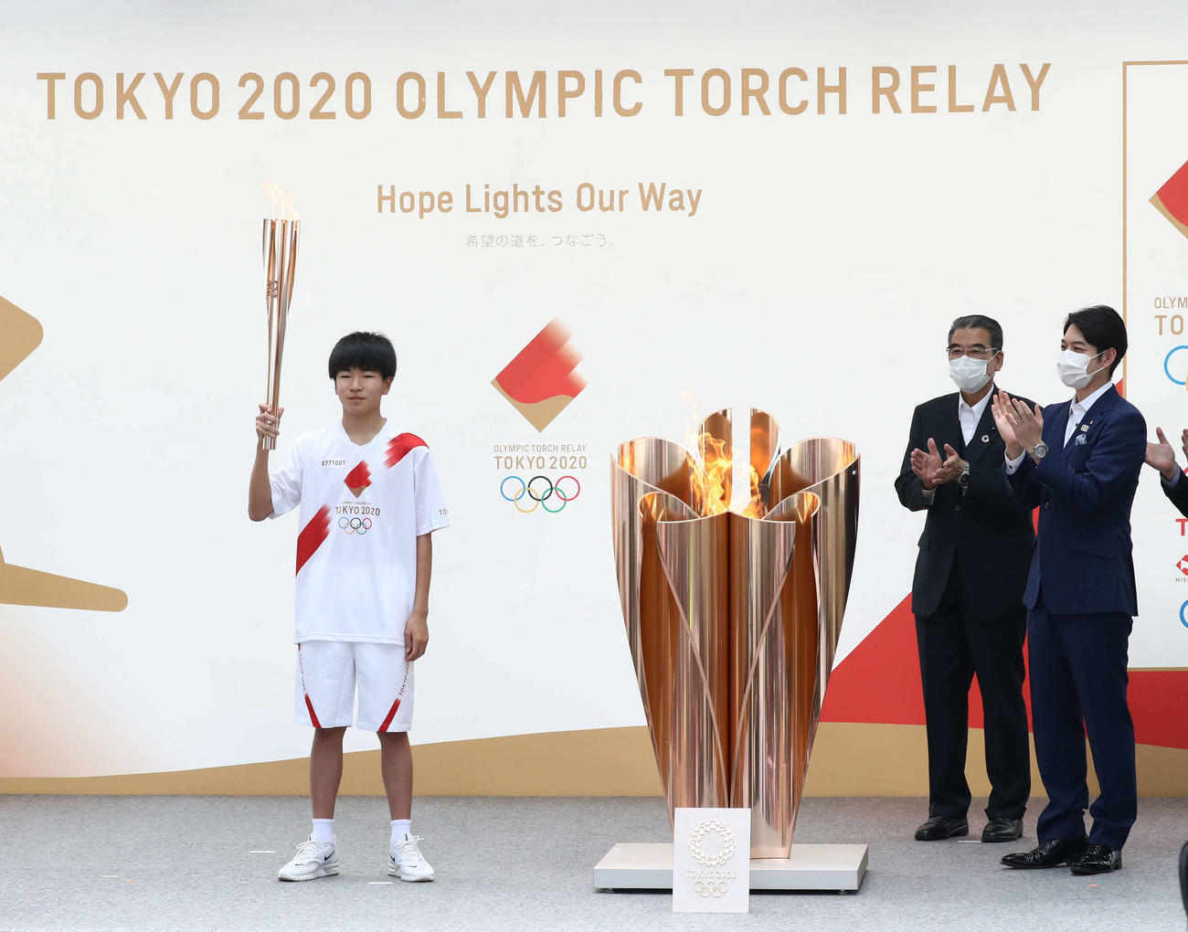 札幌市内で東京五輪の聖火の点火セレモニーを行う湯川さん。右端は鈴木北海道知事（撮影・黒川智章）