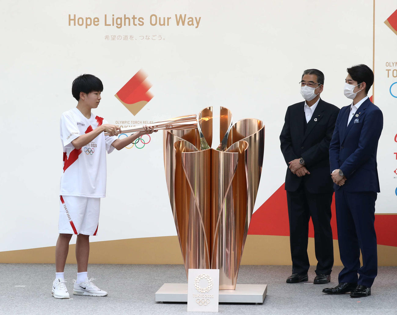 札幌市内で東京五輪の聖火の点火セレモニーを行う湯川さん。右端は鈴木北海道知事（撮影・黒川智章）