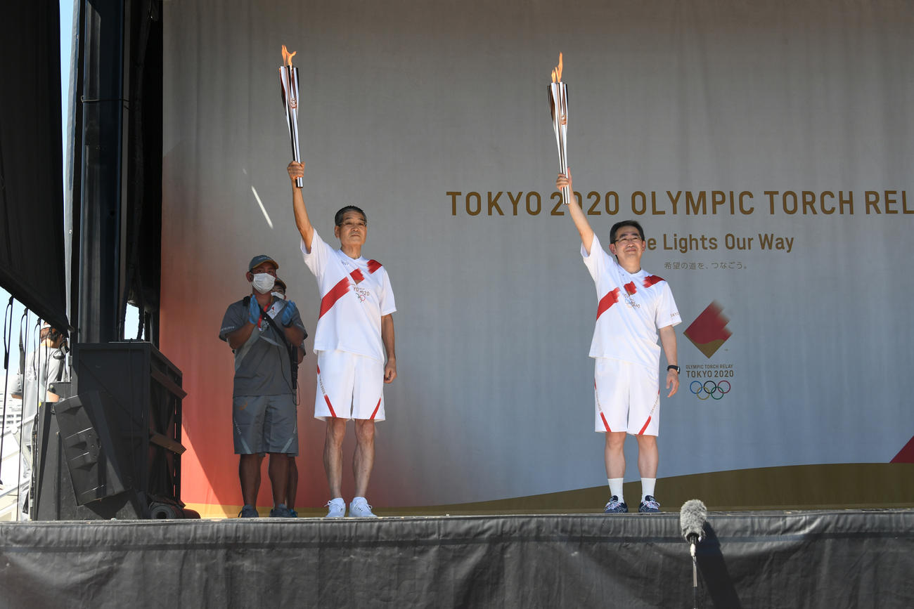 聖火ランナーを務めた落合三泰さん（左）と前走者の平岡昭良さん（代表撮影）