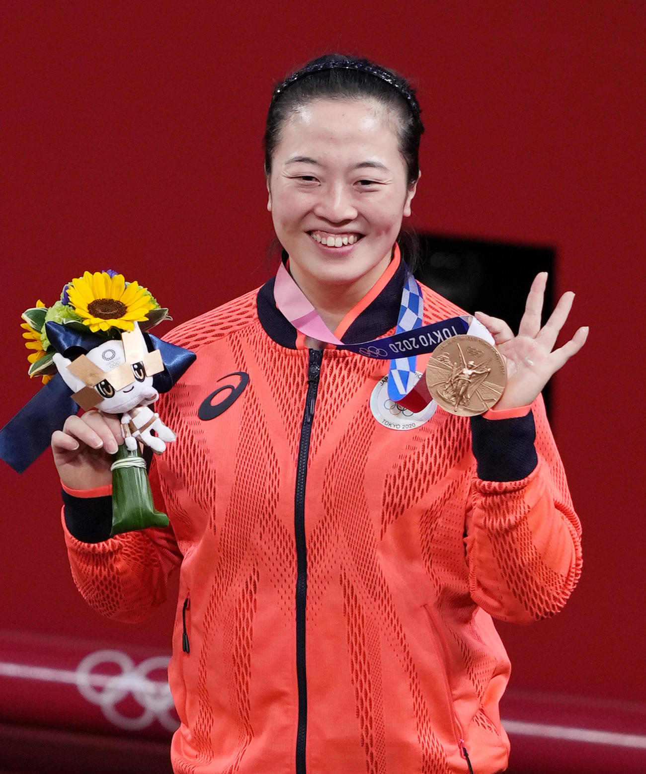重量挙げ女子59キロ級で3位の安藤は、銅メダルを手に笑顔を見せる