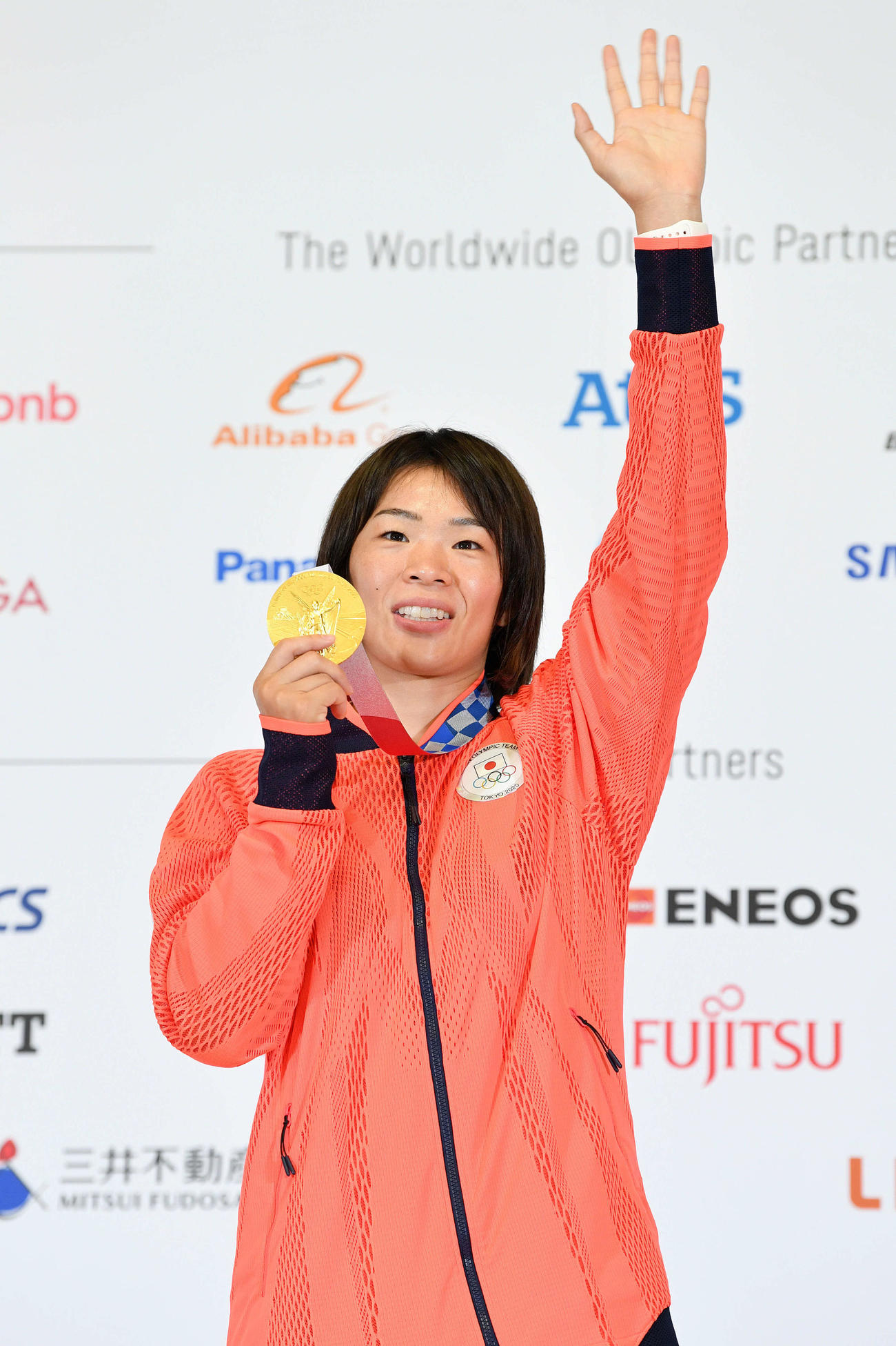 一夜明け会見を終え金メダルを手にカメラに手を振るレスリング女子の川井梨（撮影・滝沢徹郎）