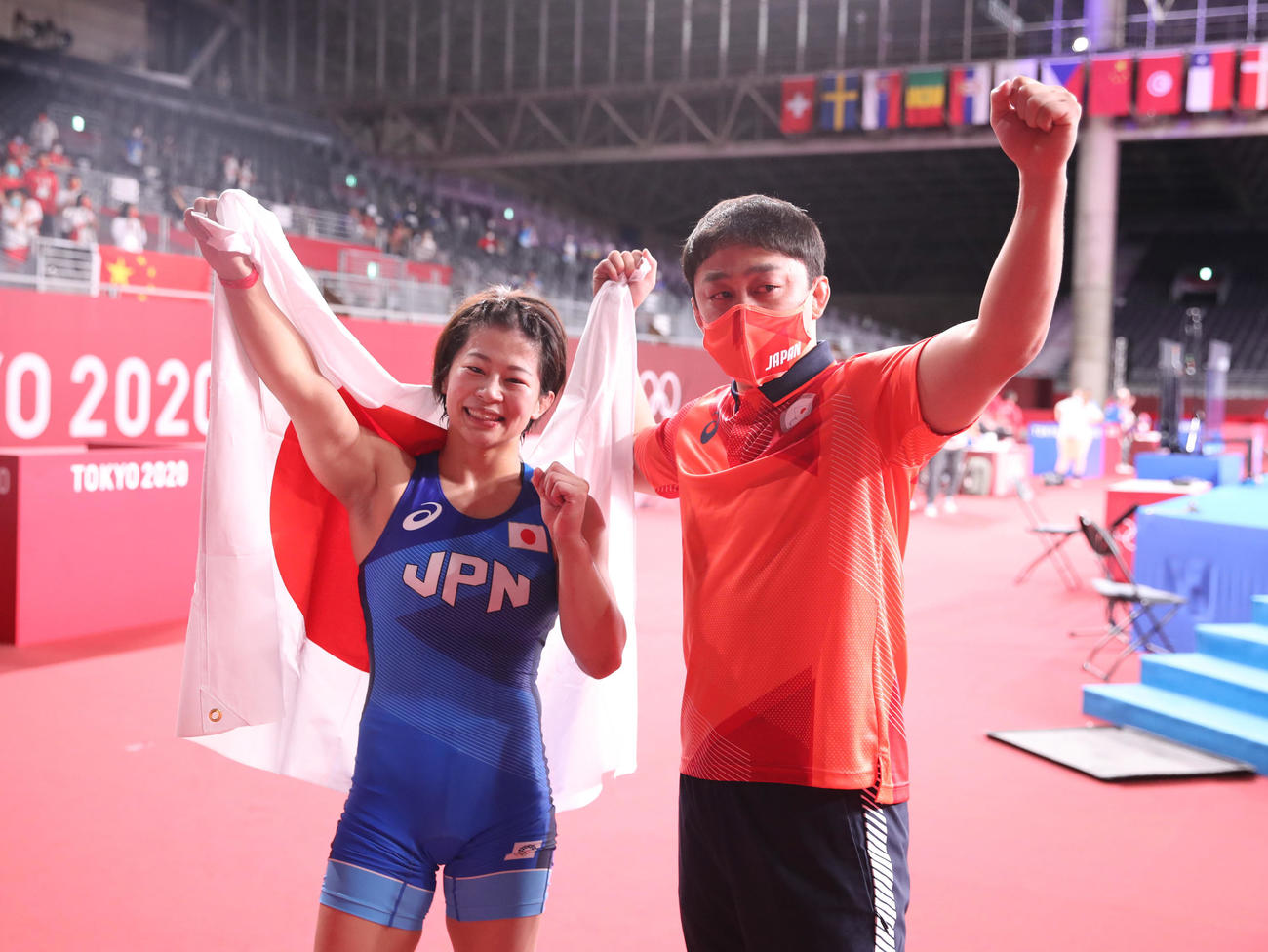 女子53キロ級で金メダルを獲得し、志土地コーチ（右）と日の丸を手に記念撮影する向田（撮影・パオロ　ヌッチ）
