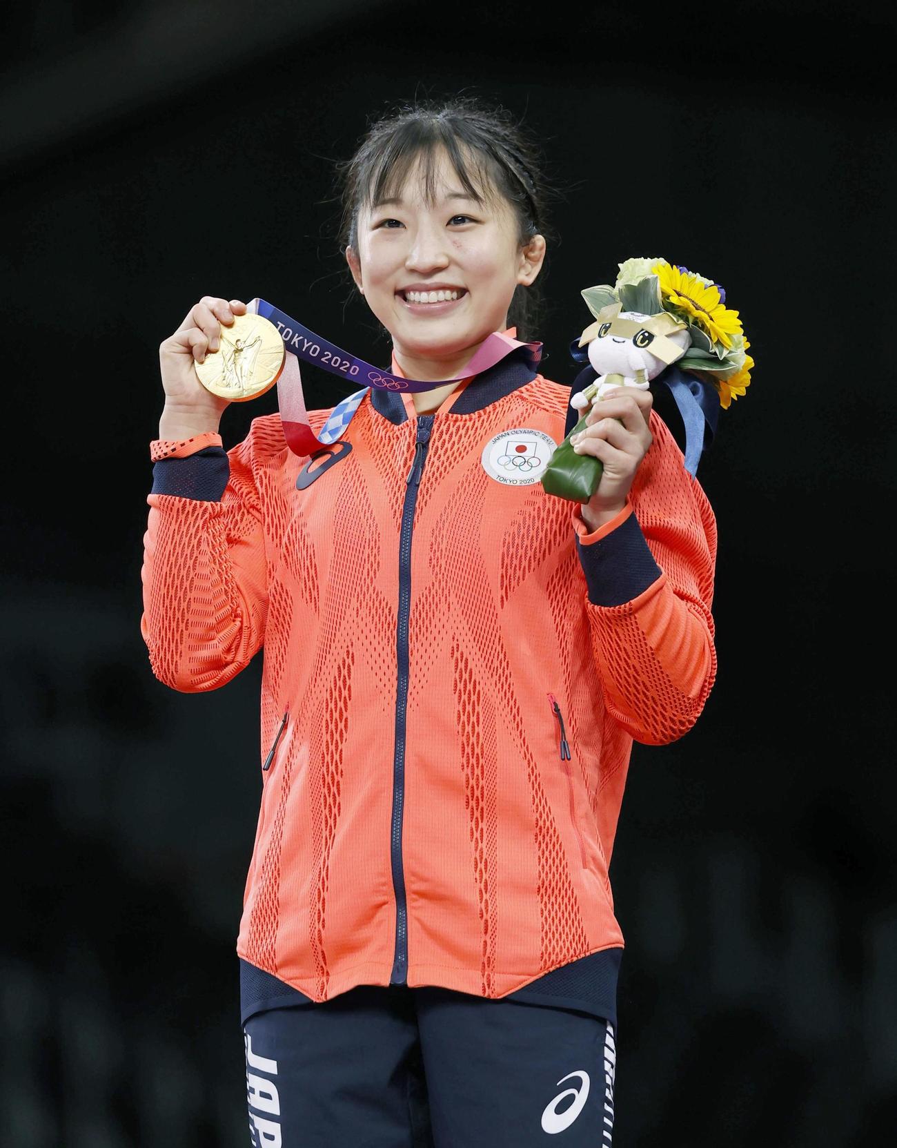 女子50 キロ 級で優勝し、笑顔で金メダルを手にする須崎優衣＝幕張メッセ（共同）