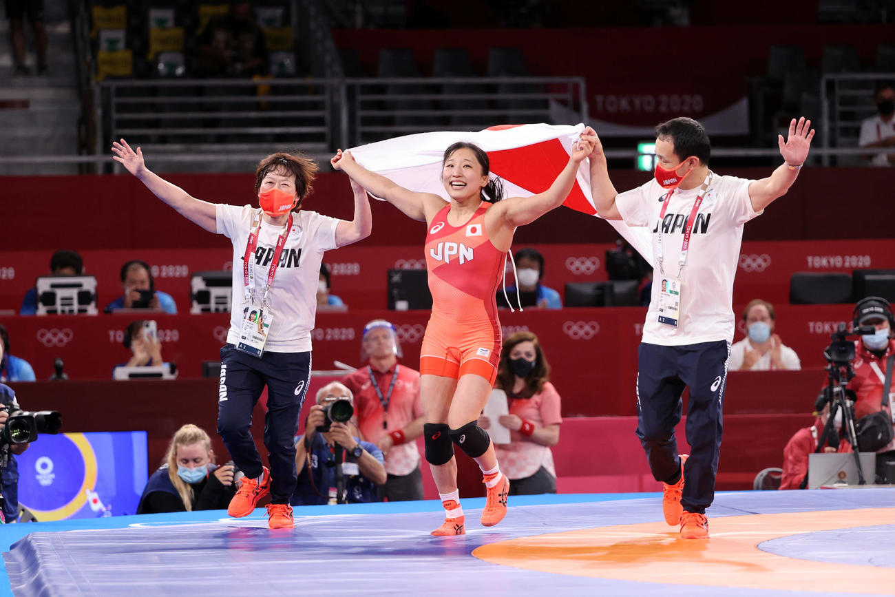 女子フリースタイル50キロ級決勝　金メダルを獲得し、日の丸を掲げ、吉村コーチ（左）、笹山コーチ（右）といっしょにマットをまわる須崎（撮影・パオロ　ヌッチ）