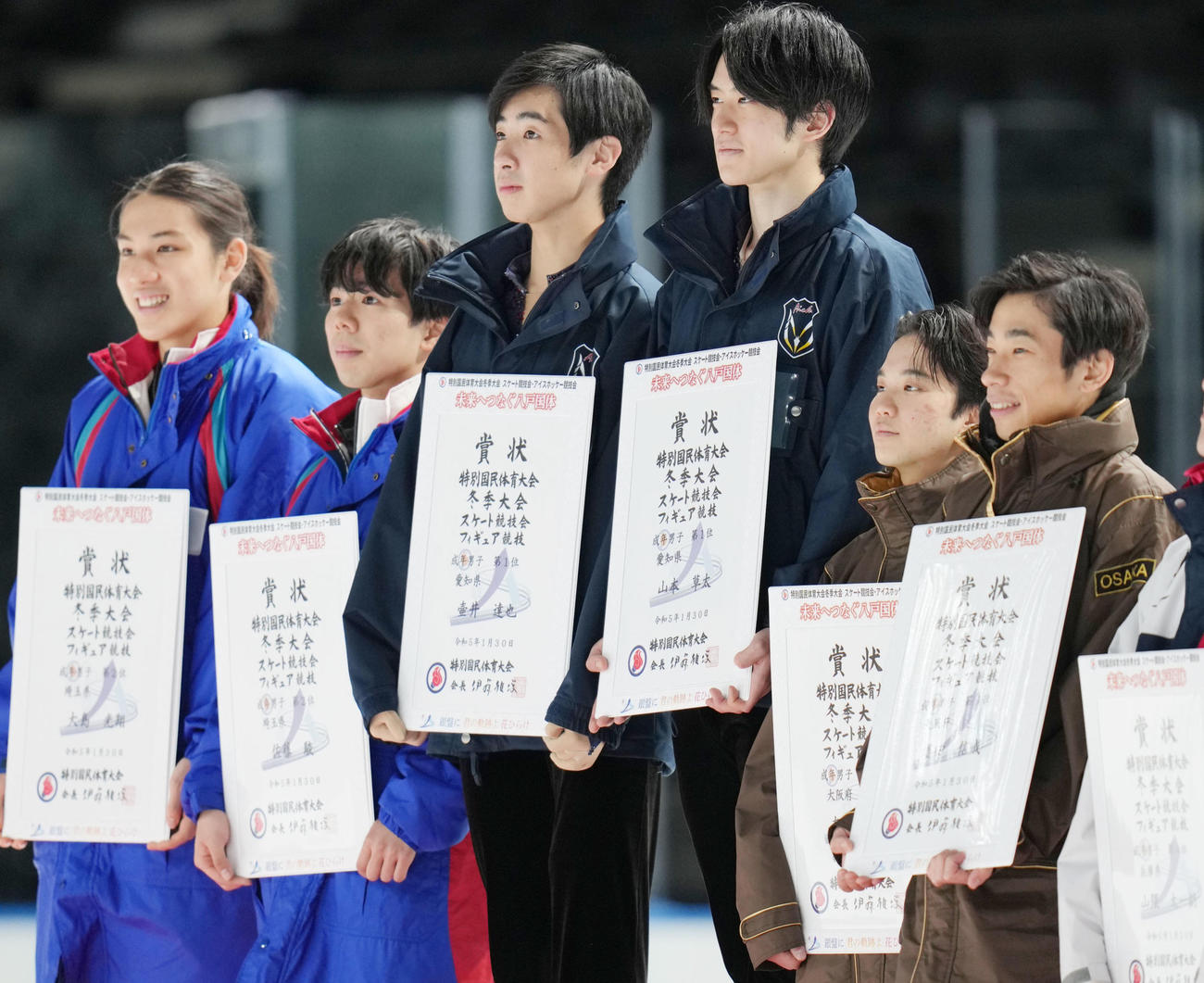 成年男子フィギュアスケートの表彰式で賞状を持つ、1位愛知の壷井（中央左）と山本（同右）。左から2位埼玉の大島、佐藤駿、2人おいて3位愛知の友野、織田