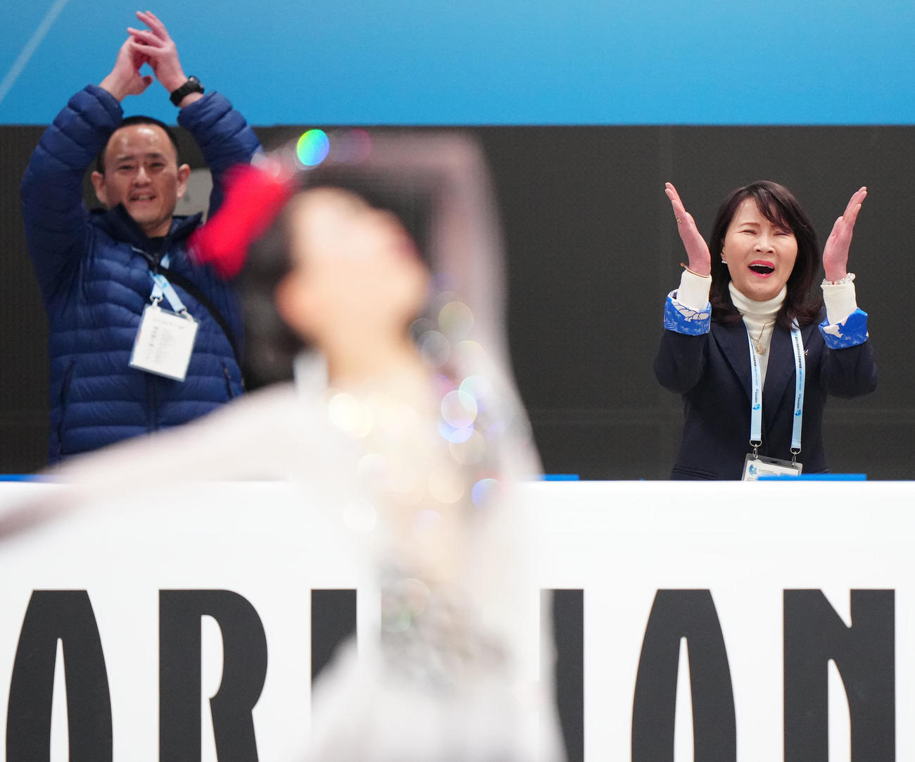 吉田（手前）の女子フリーの演技後、拍手する浜田コーチ（右）