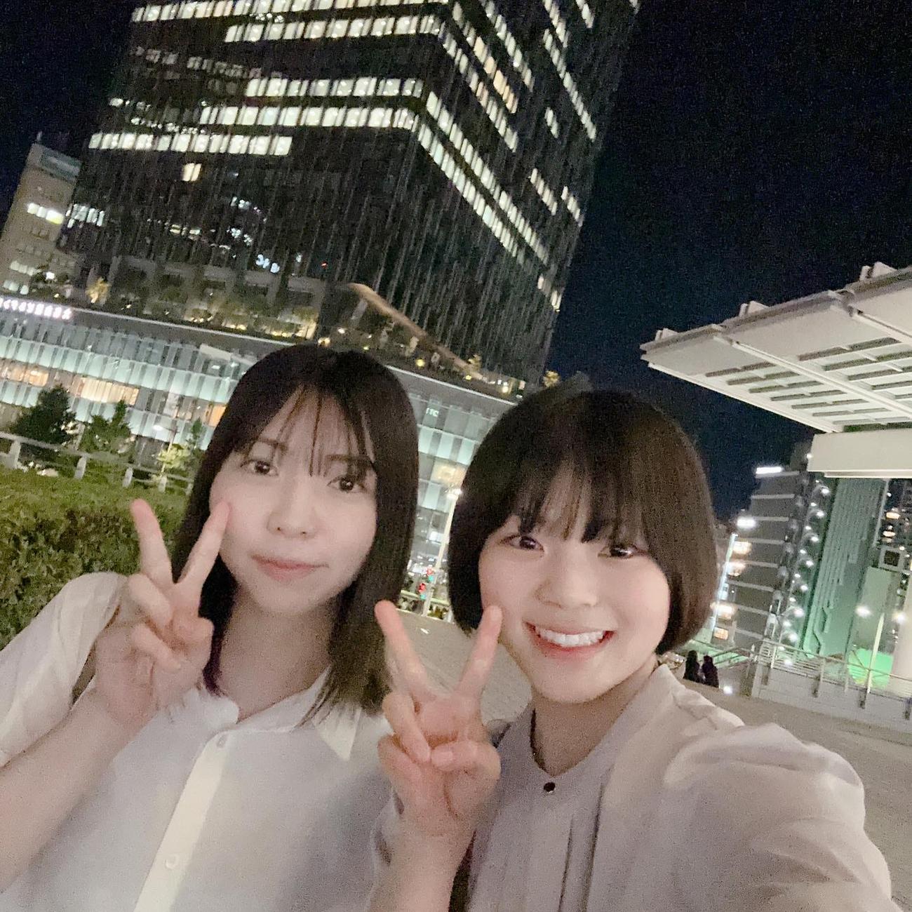 同期の井上未都（左）と夜景をバックにピースサイン