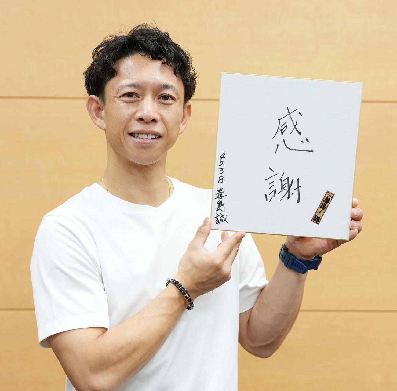 「感謝」と記した色紙を手にする毒島誠（撮影・小沢裕）