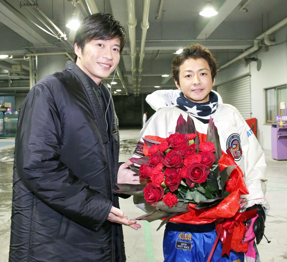 グランプリを制した石野貴之（右）は田中圭から花束を受け取り笑顔を見せる（撮影・上山淳一）