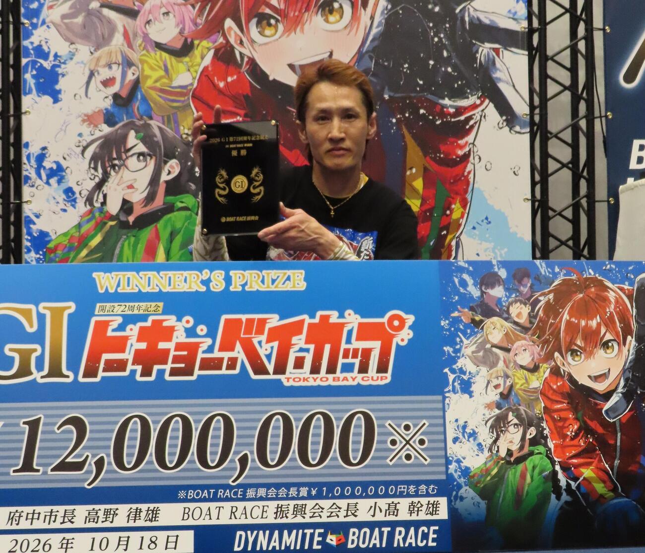 金メダルを埋め込んだ優勝盾を持つ白井英治