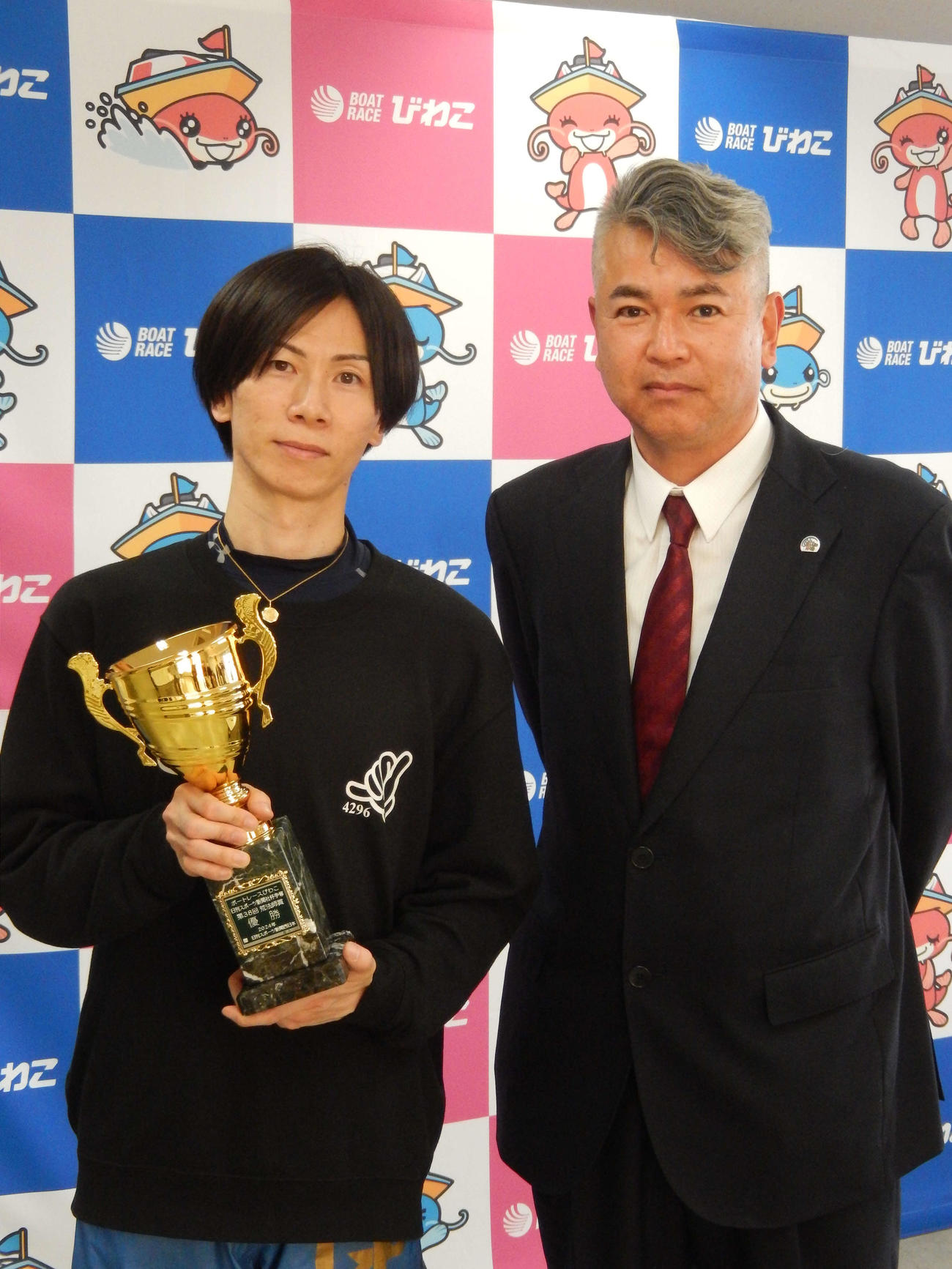 優勝した岡崎恭裕（左）と日刊スポーツ新聞社メディアビジネス局・早川治道局長