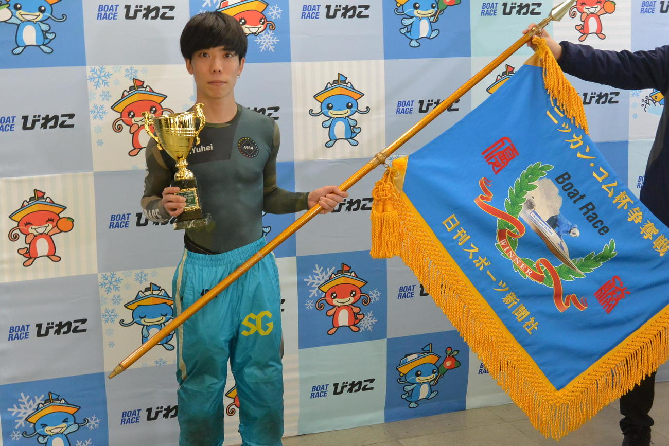 優勝した吉田裕平が記念トロフィーと優勝旗を手にした